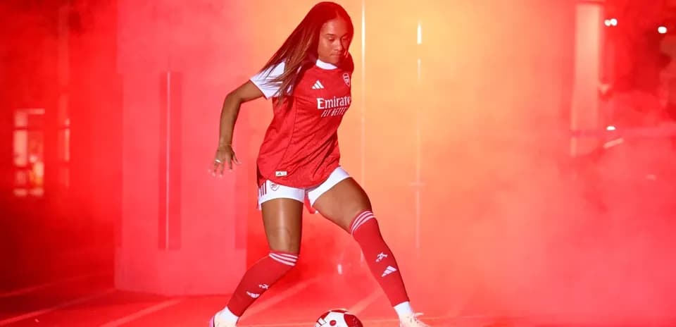 Player dribbling a soccer ball in red smoke