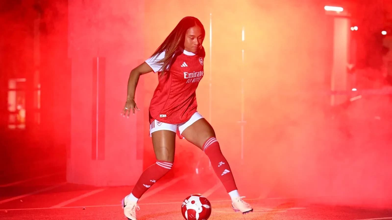 Player dribbling a soccer ball in red smoke
