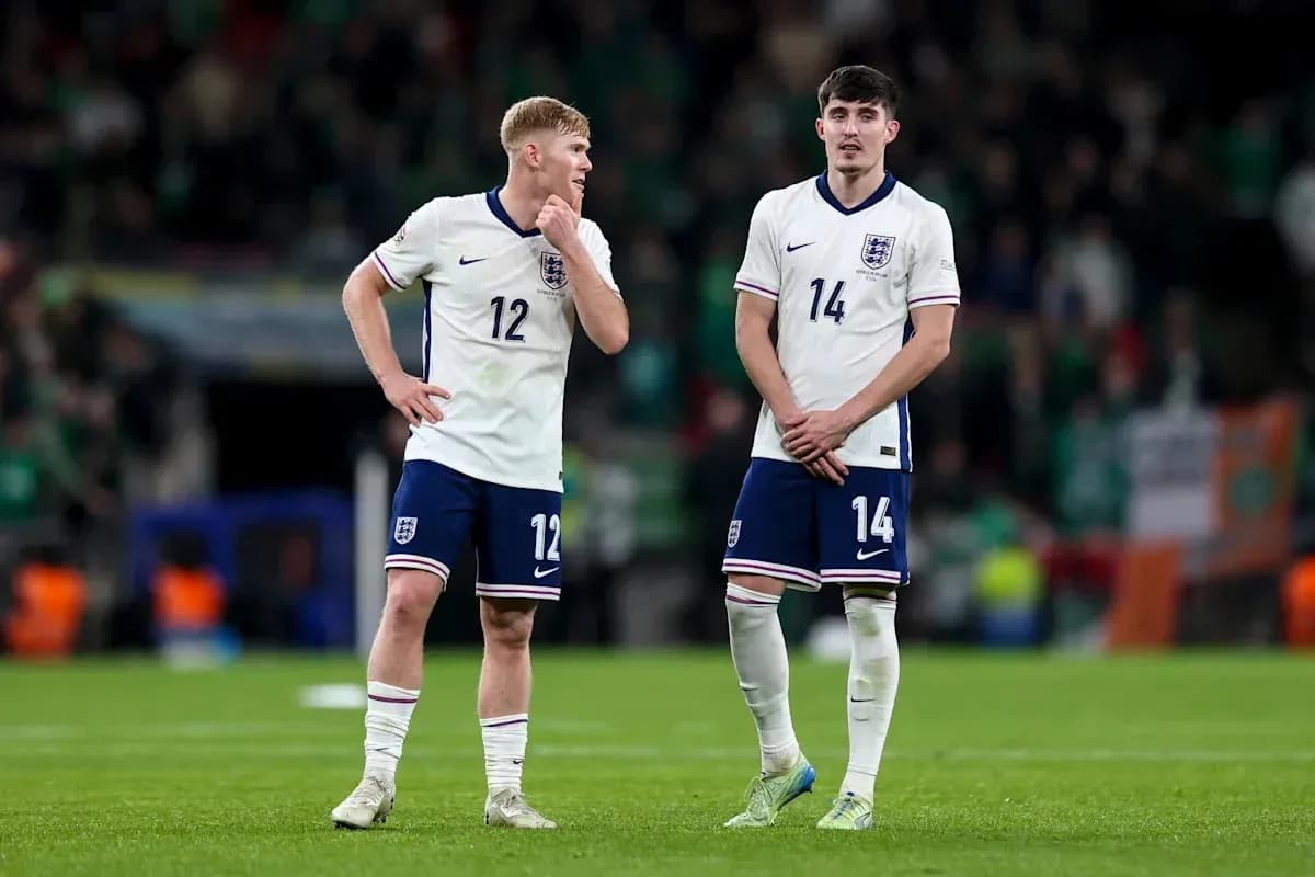 Two England players standing on the pitch after match
