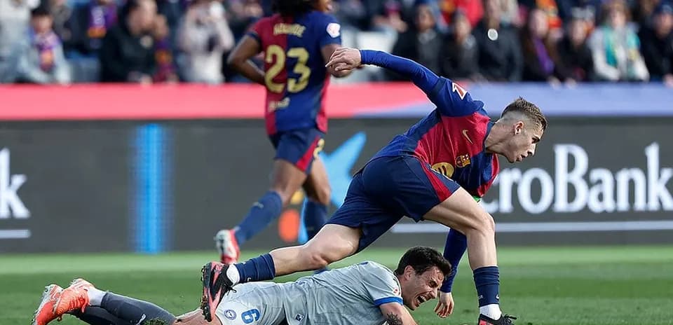 Barcelona player tackling Alaves goalkeeper during match