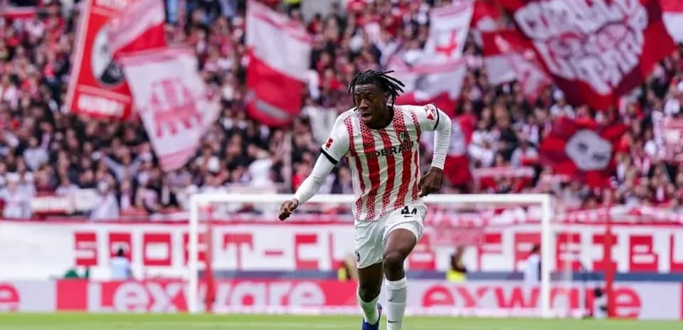 Player dribbling the ball with fans cheering behind