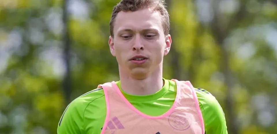 Goalkeeper training in a green jersey and pink bib