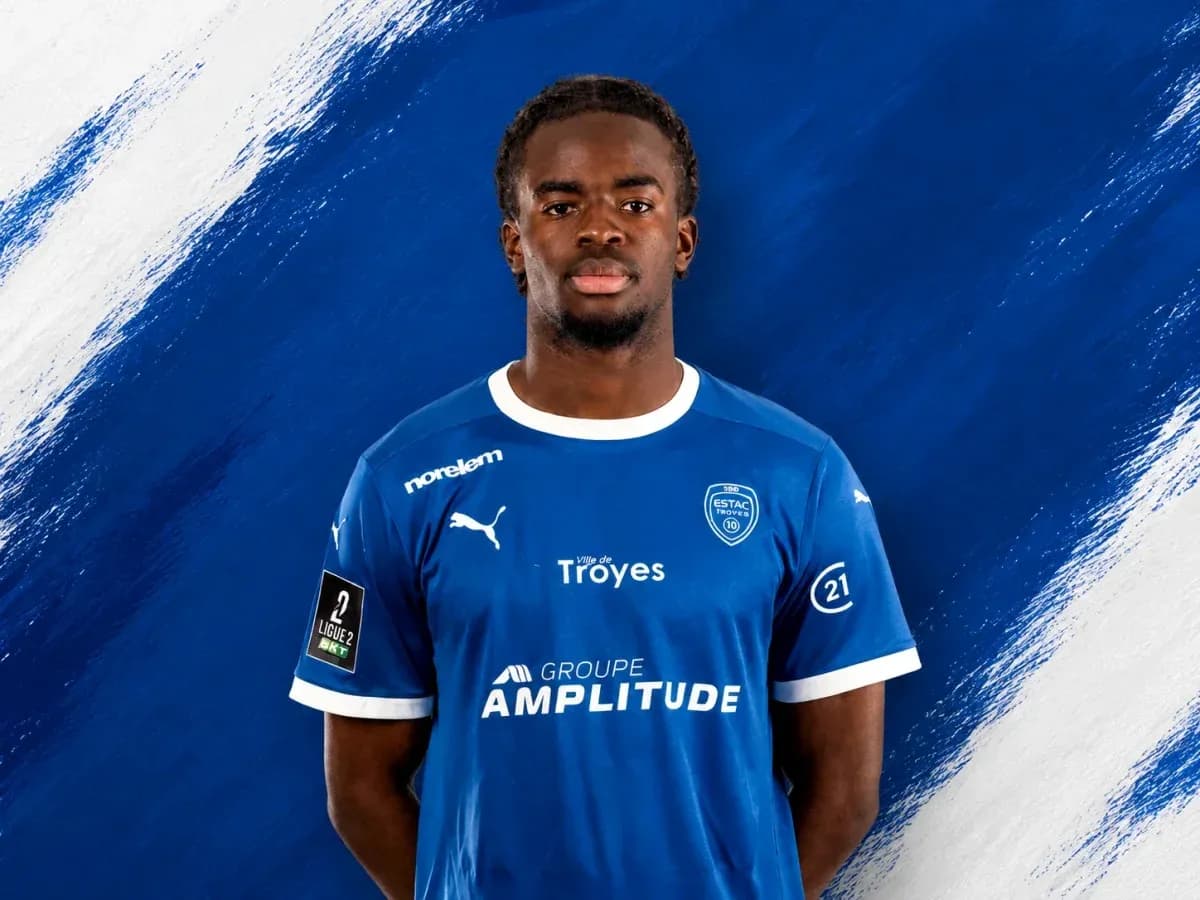 Player in blue ESTAC Troyes jersey against blue background