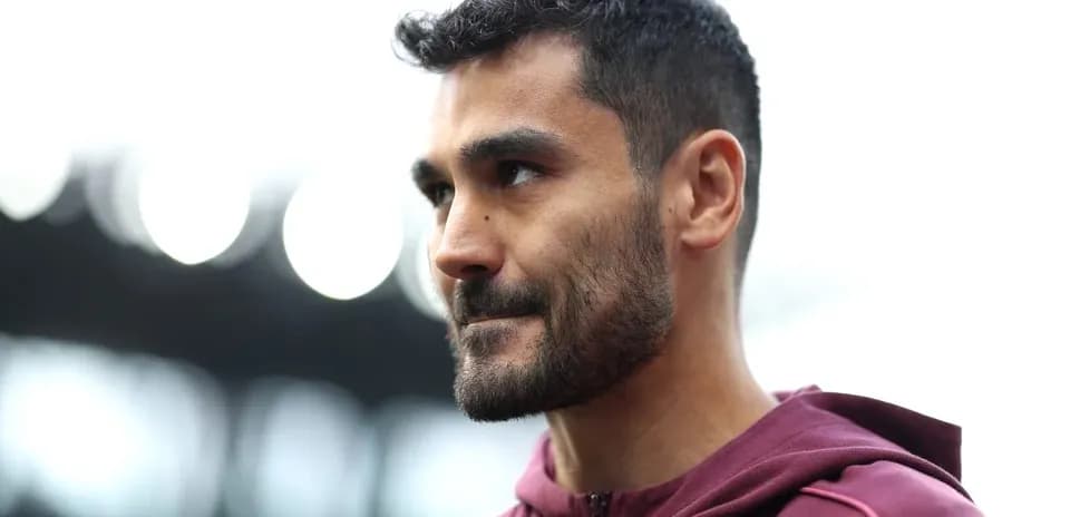 Player wearing maroon hoodie on stadium field