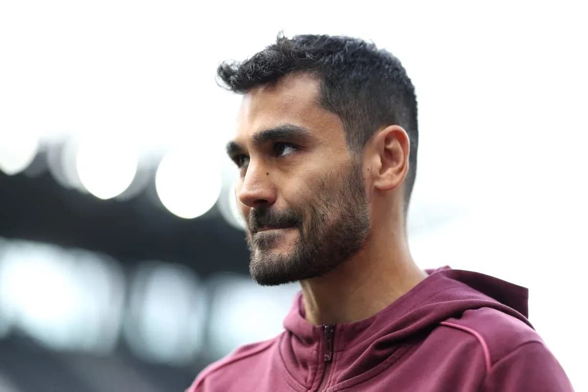 Player wearing maroon hoodie on stadium field