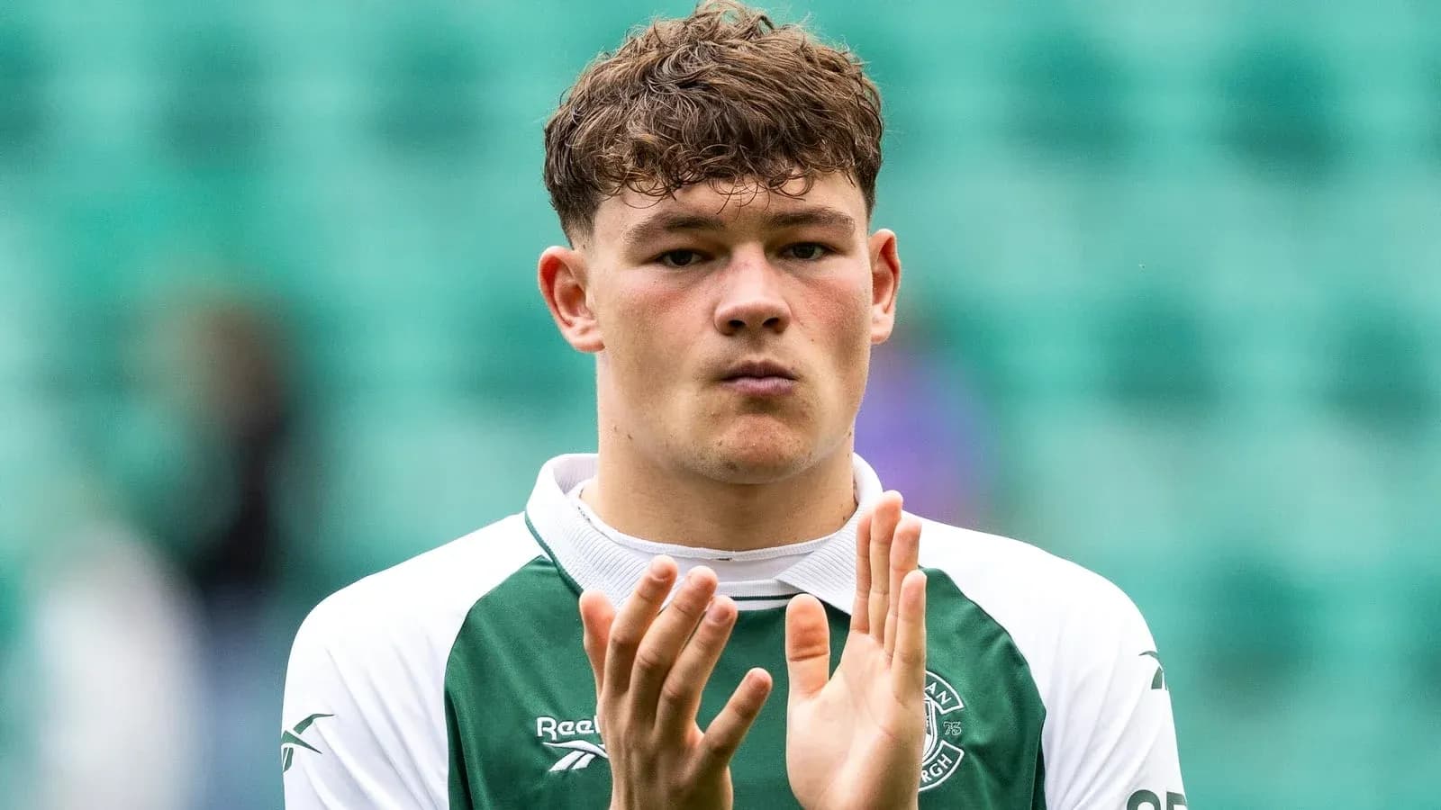 Player applauding in Hibernian kit on pitch