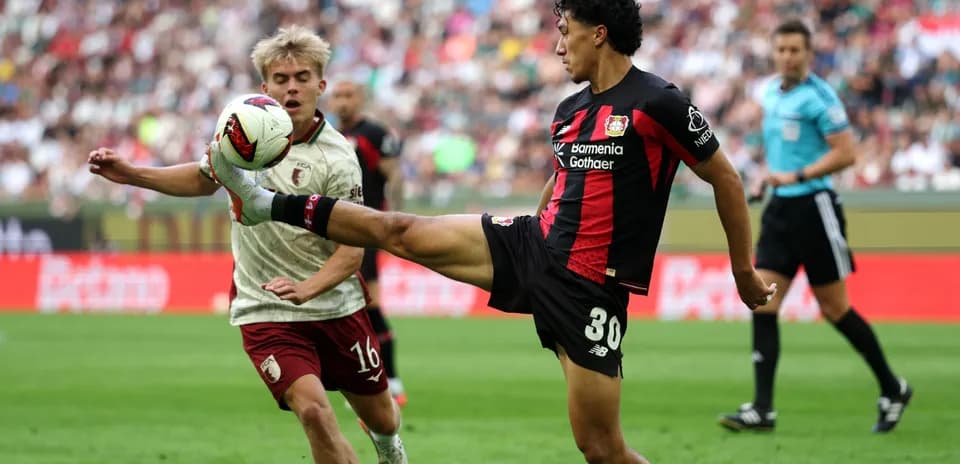 Player kicking ball while opponent approaches during match