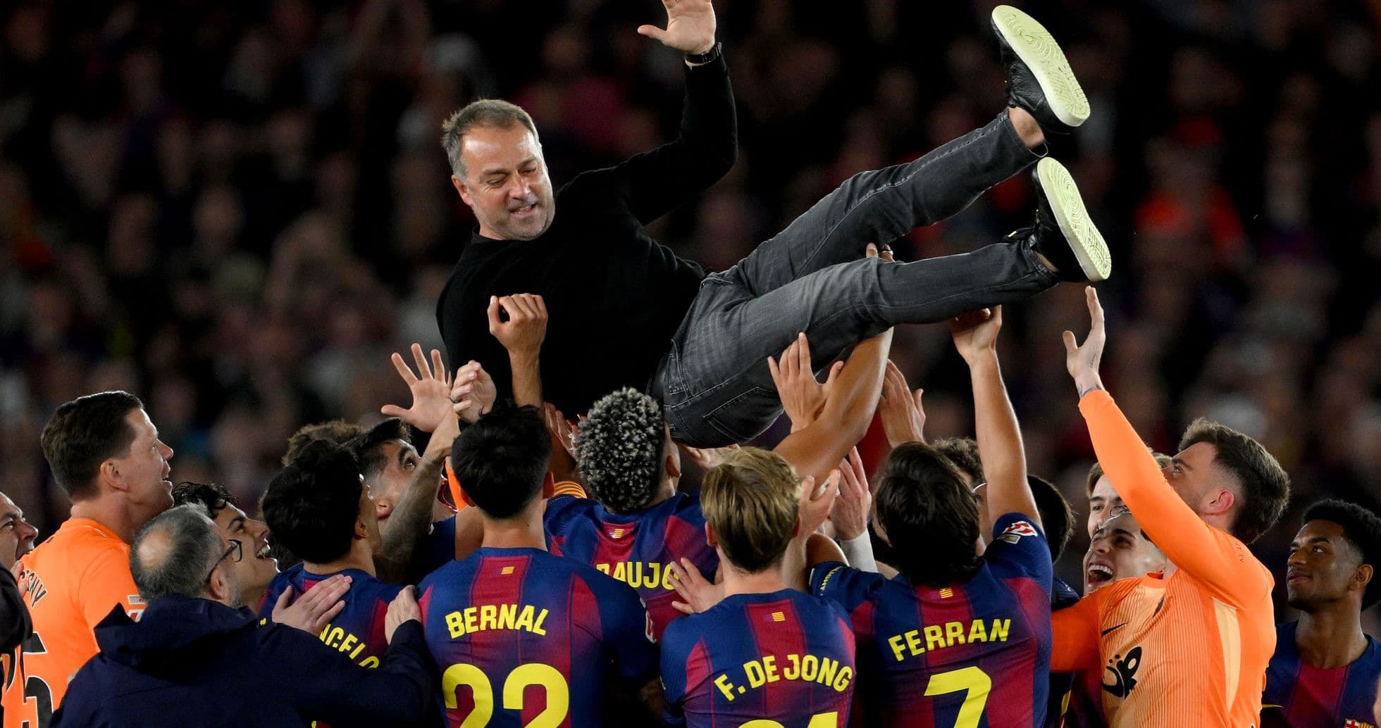 Barcelona players celebrating and lifting their coach