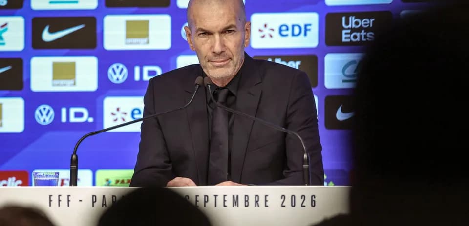 Manager speaking at press conference with logos behind