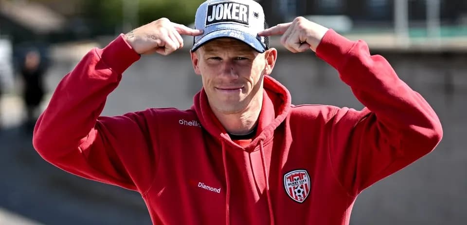 Man wearing a 'JOKER' cap and red hoodie
