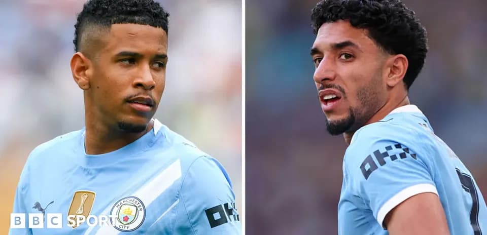 Two Manchester City players in match uniforms