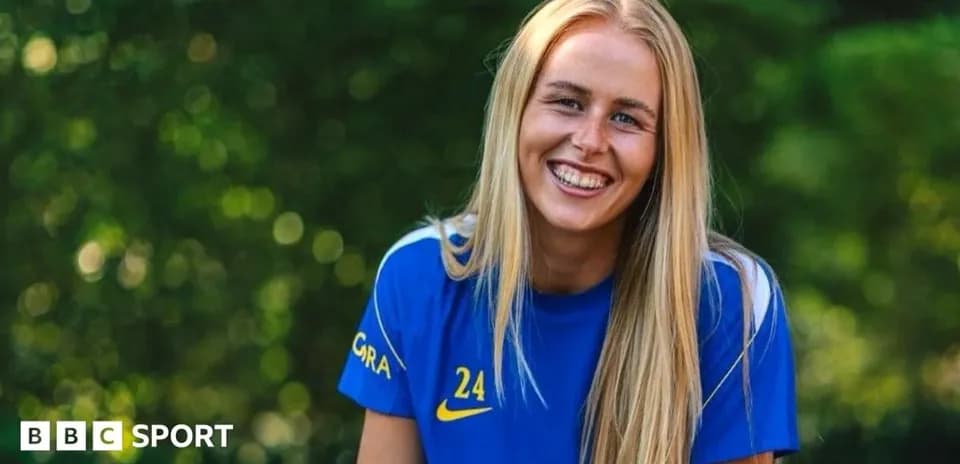Player smiling in blue team jersey outdoors