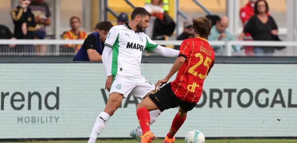 Sassuolo player tackling Lecce opponent on field