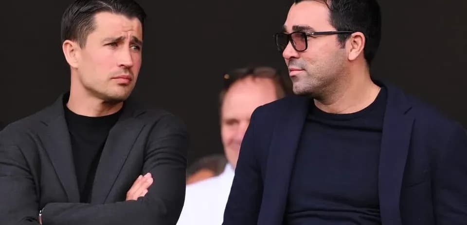 Two men in suits watching an event together