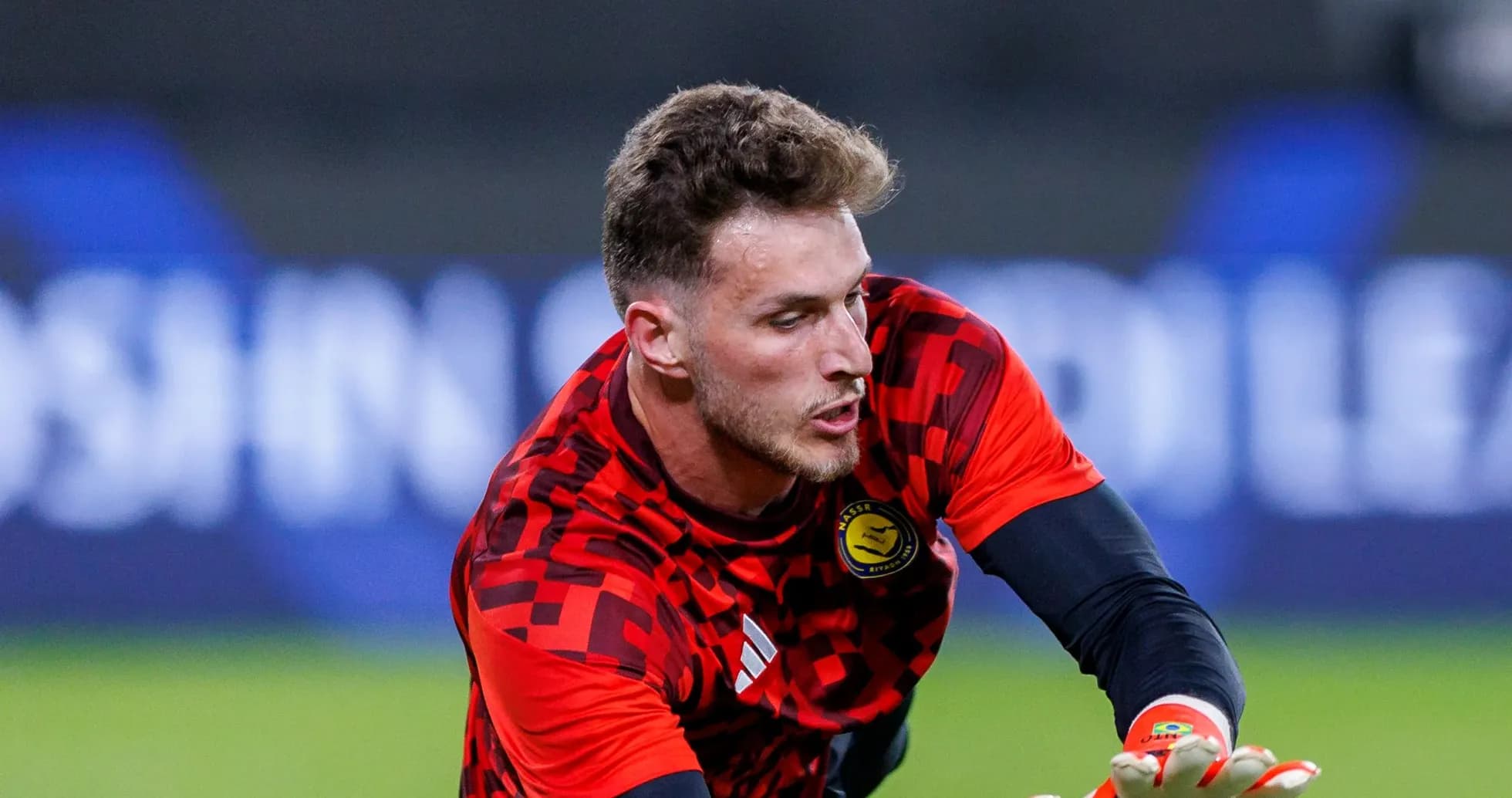 Goalkeeper training with gloves in red kit