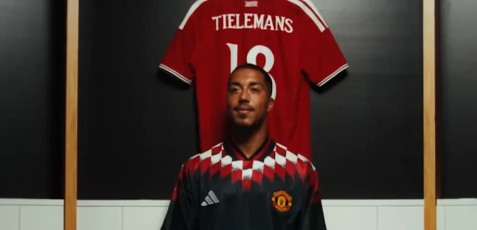 Player wearing Manchester United jersey in locker room