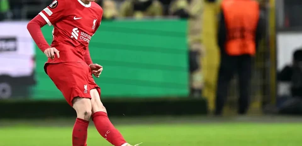 Player in red kit kicking a soccer ball