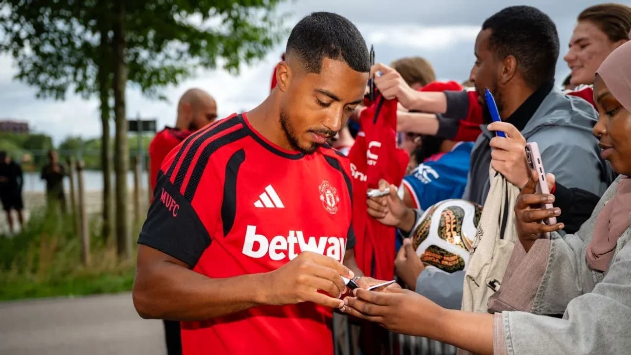Player signing autographs for fans outside