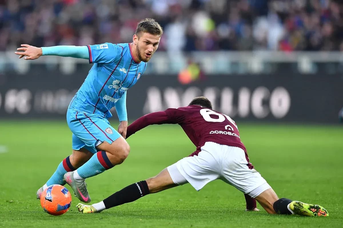Cagliari player evading a tackle from Torino opponent