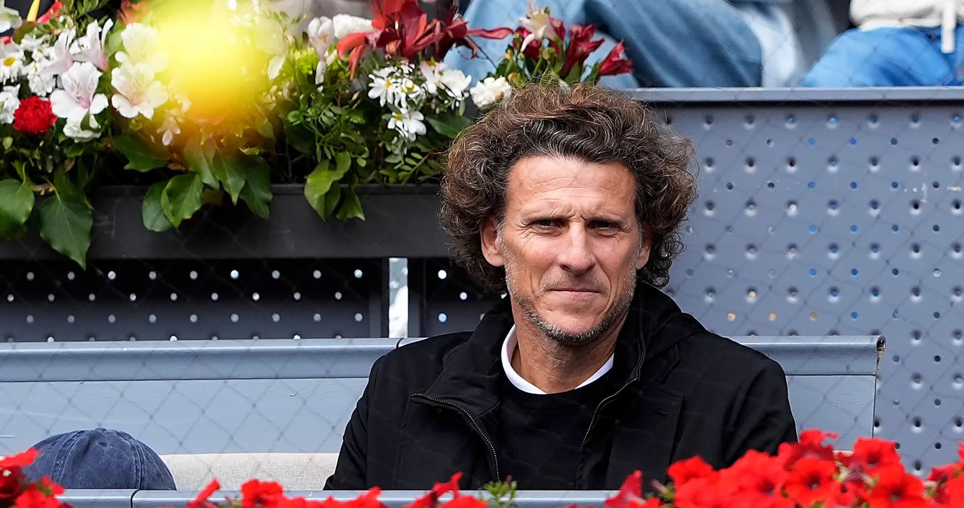 Person seated among flowers at tennis event