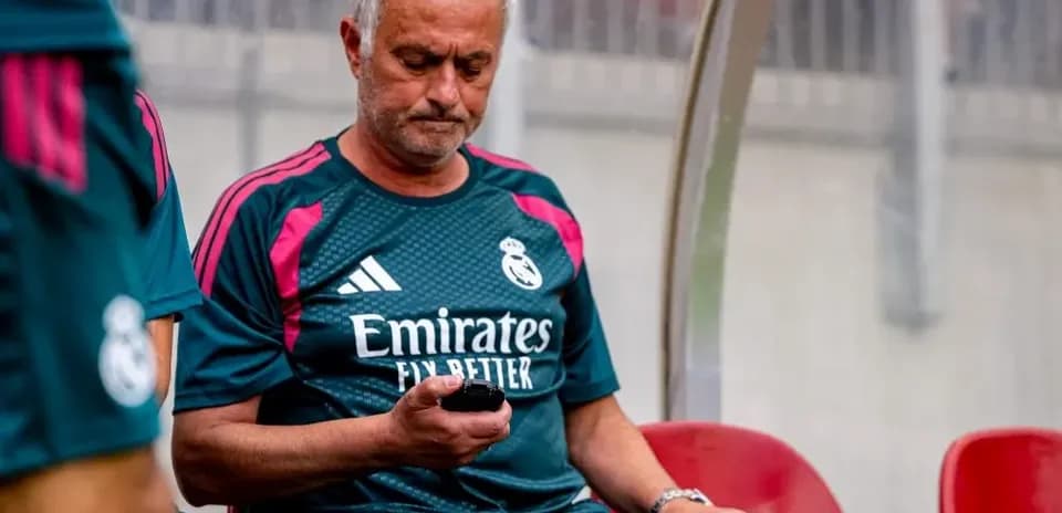 Coach checking phone on bench during match