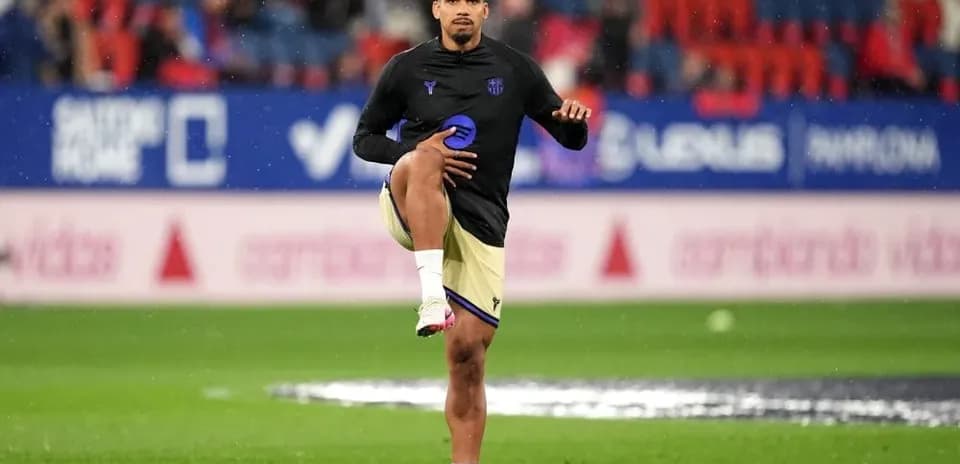 Player stretching leg during warm-up on pitch