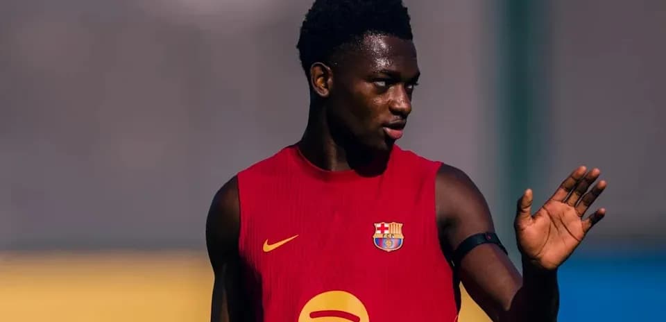 Player in Barcelona training kit gesturing on field