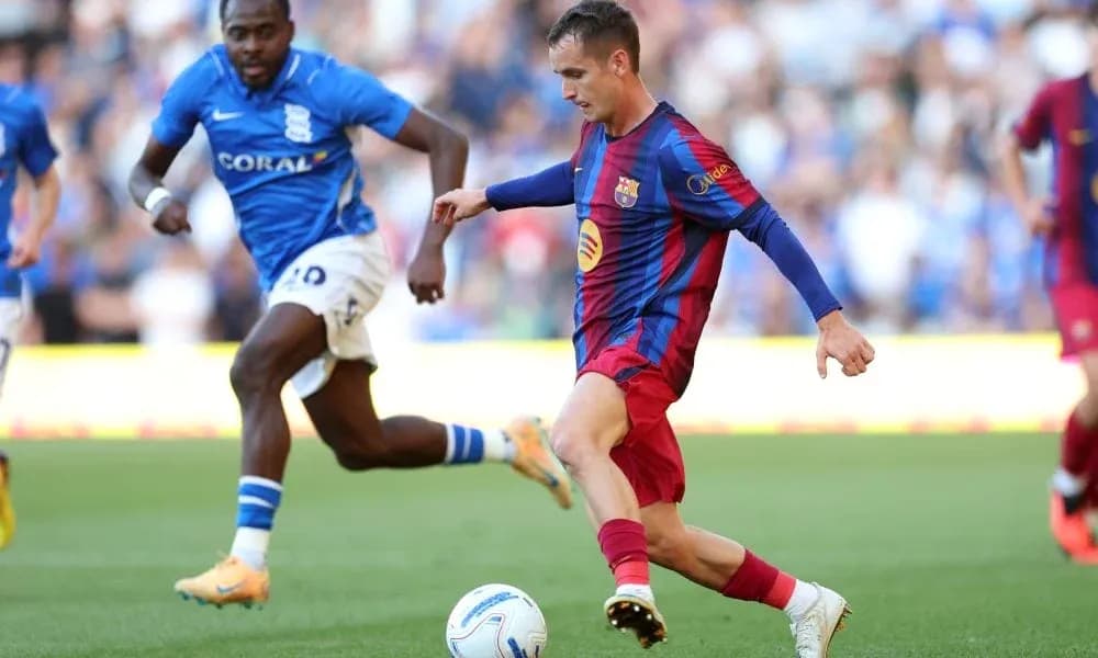 Barcelona player dribbling past Birmingham defender