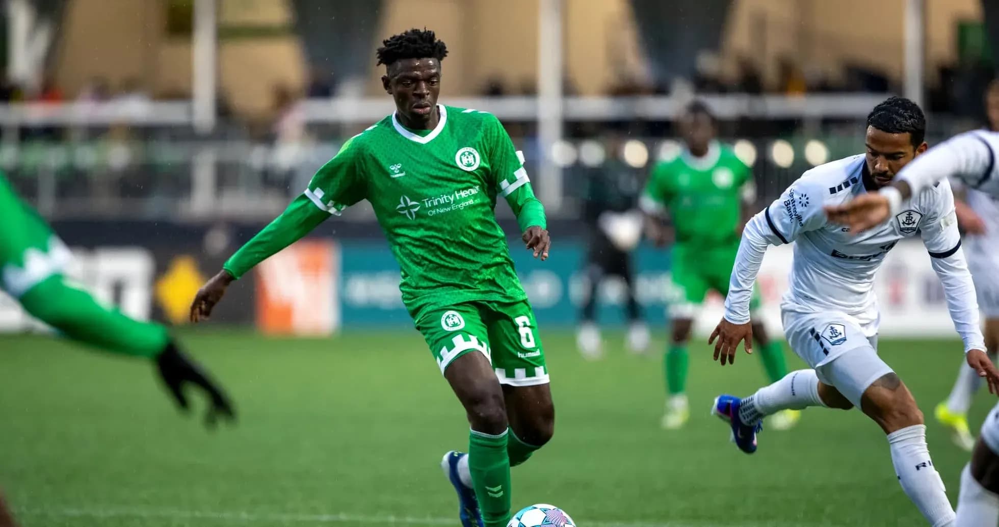 Player in green jersey dribbling the ball