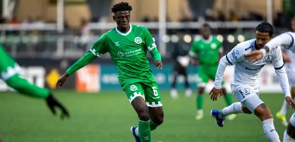 Player in green jersey dribbling the ball