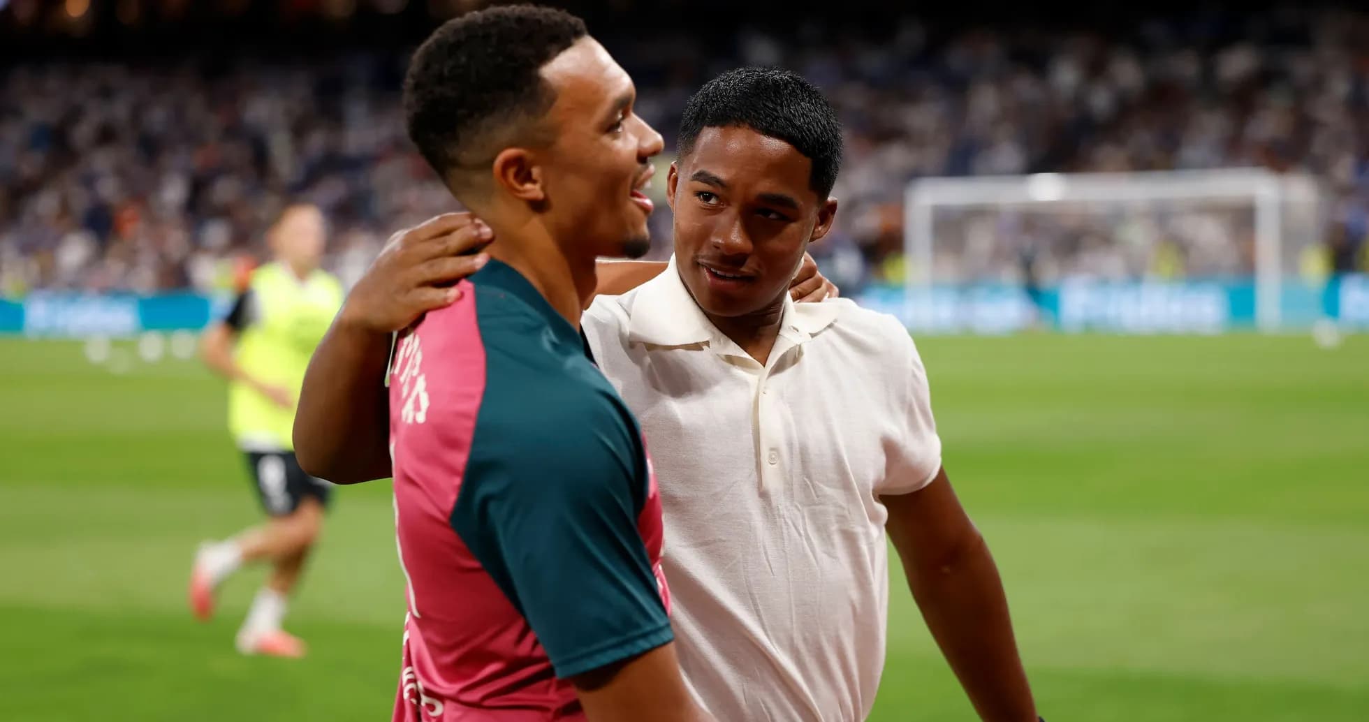 Two players embracing on the pitch before a match
