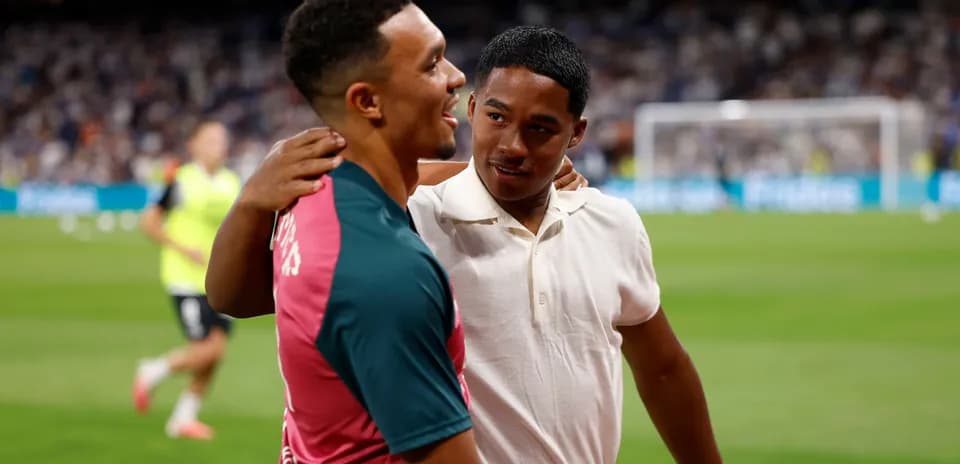 Two players embracing on the pitch before a match