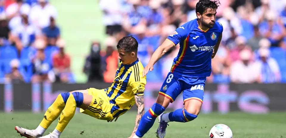 Oviedo player tackling Getafe opponent during match