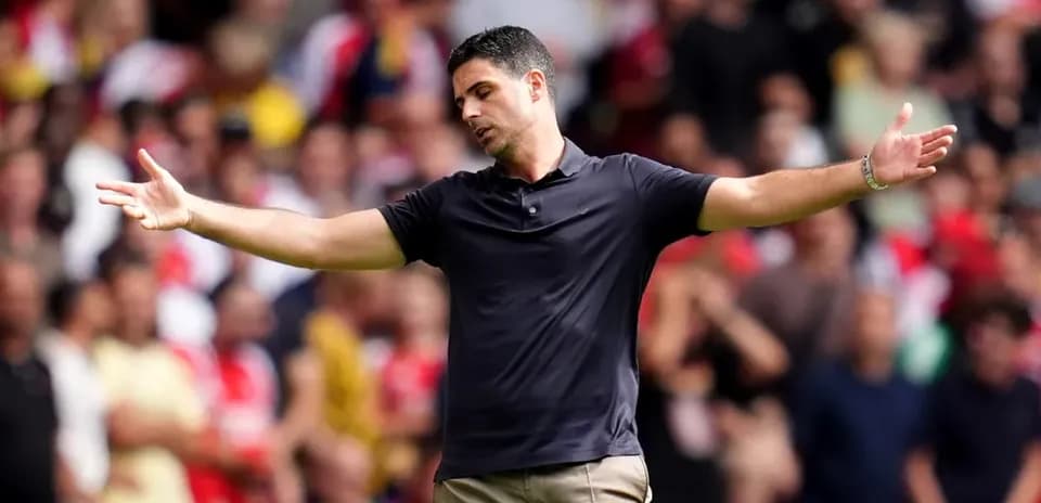 Manager gesturing to fans during a match