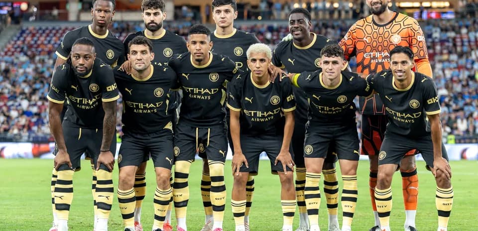 Team posing for photo in black kits on field