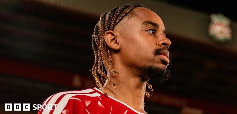 Player in red kit at stadium during photo shoot
