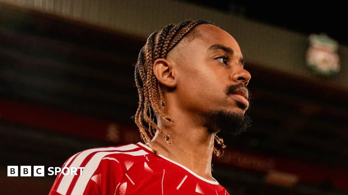Player in red kit at stadium during photo shoot