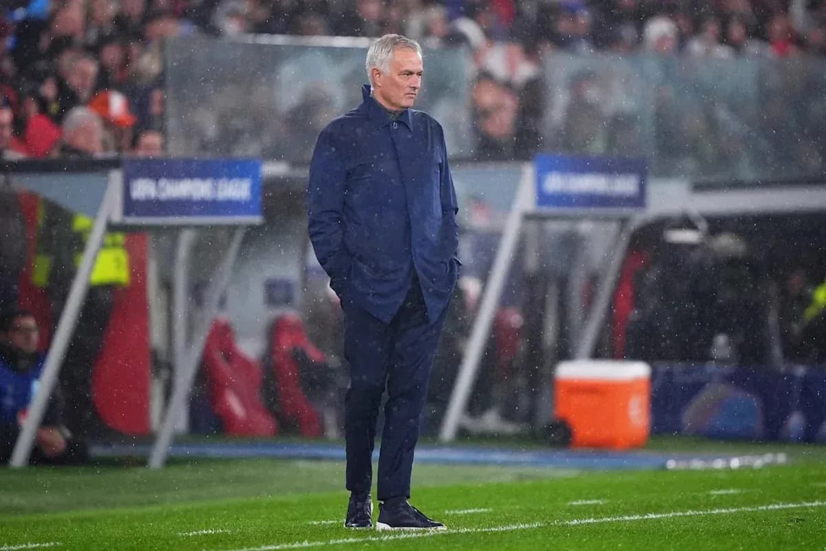 Coach standing on sidelines during rainy match