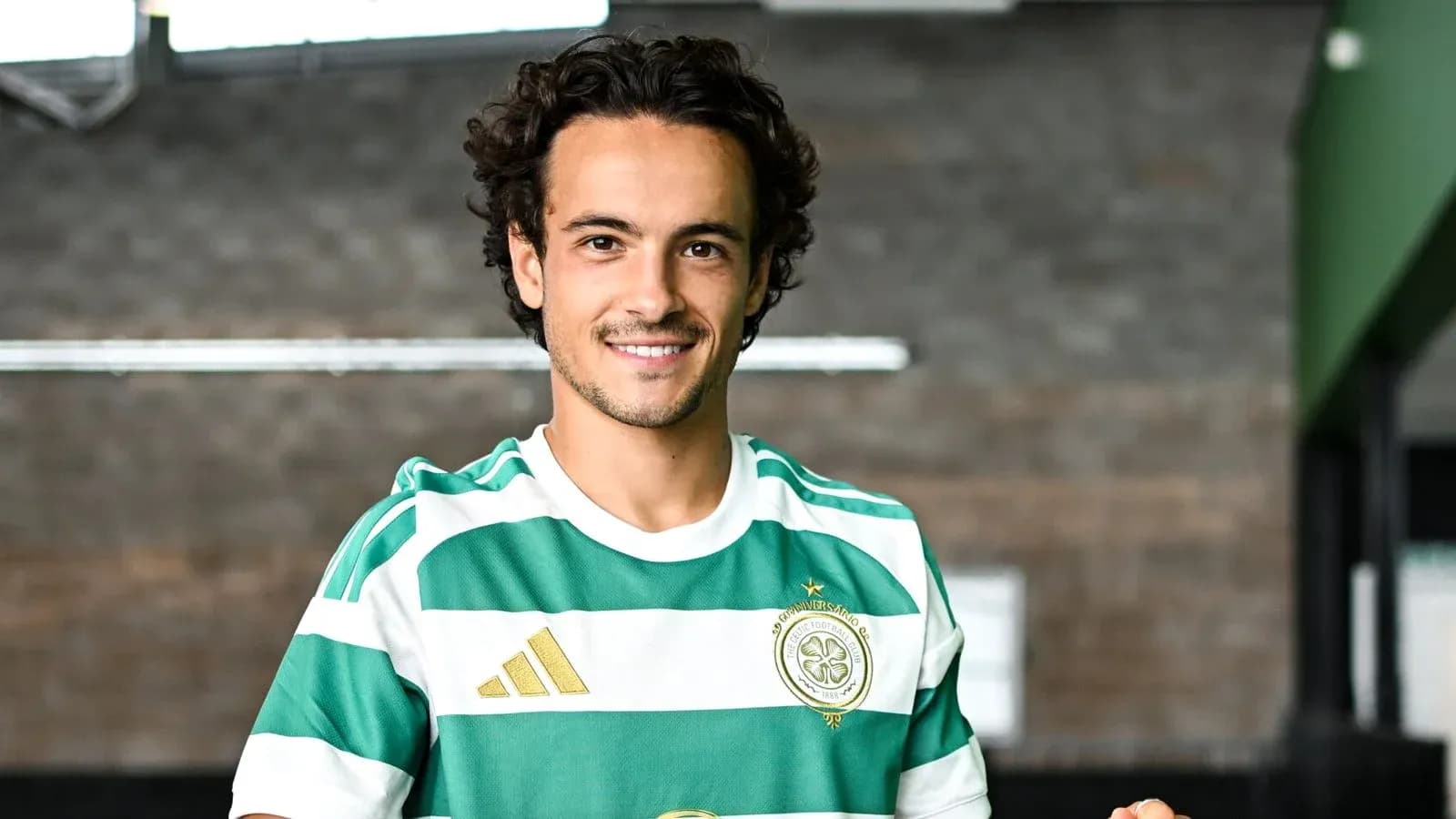 Player in green and white striped jersey posing