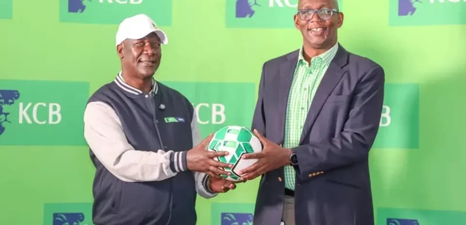 Two men holding a soccer ball at KCB event
