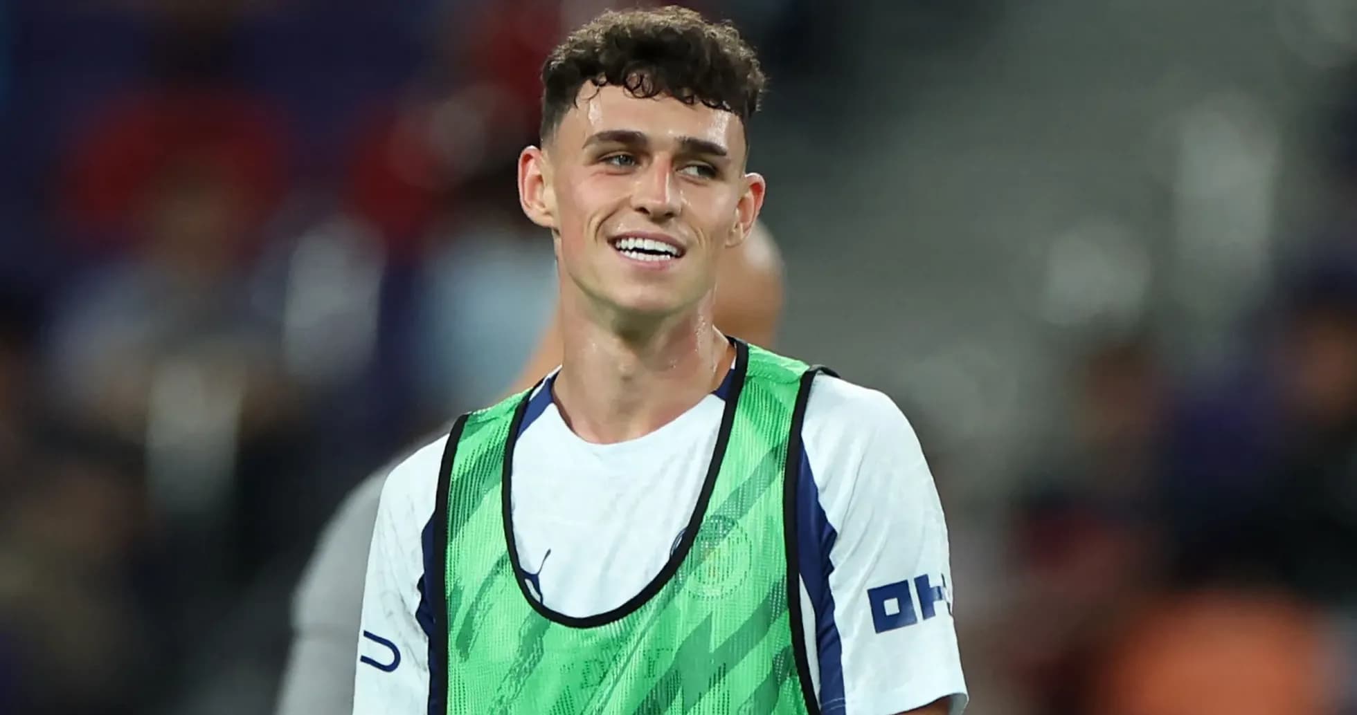 Player in training bib smiling on the pitch