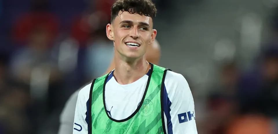 Player in training bib smiling on the pitch