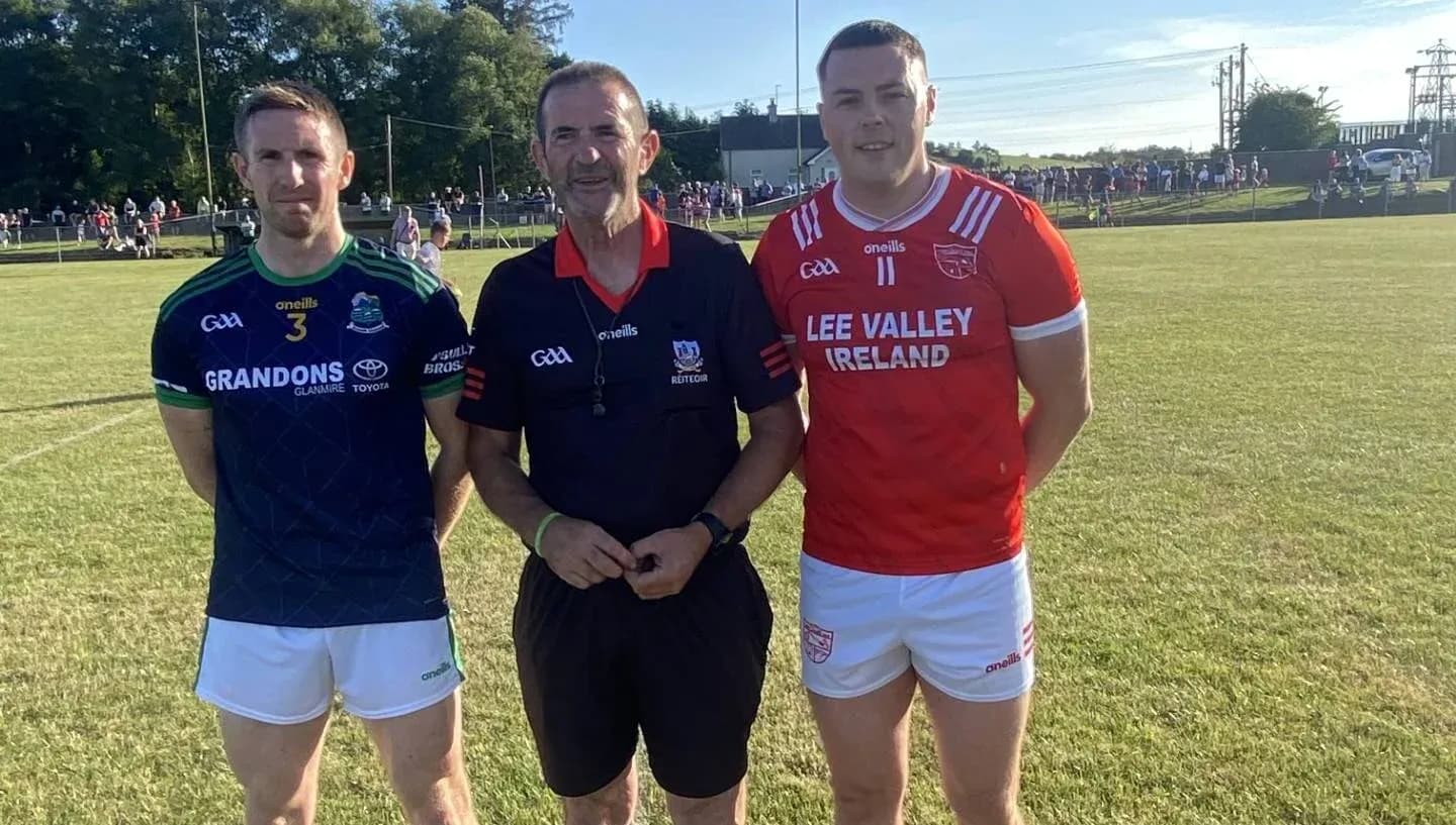 Two players and referee posing on the field