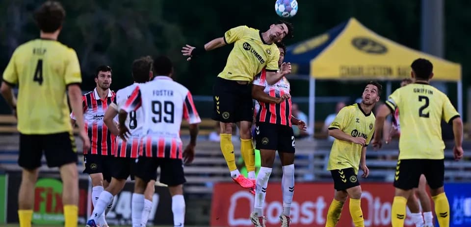 Players contesting a header during match