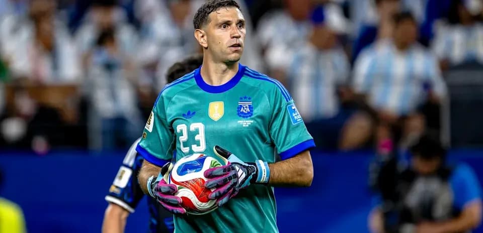 Goalkeeper in green kit holding a soccer ball