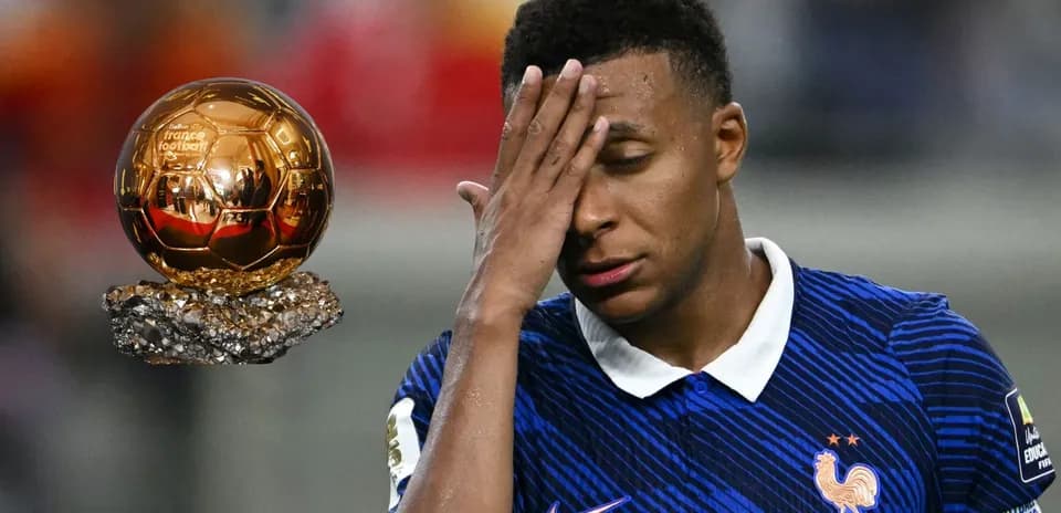 Player with hand on forehead beside Ballon d'Or trophy