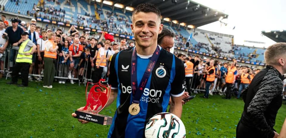 Player holding trophy and ball in celebration
