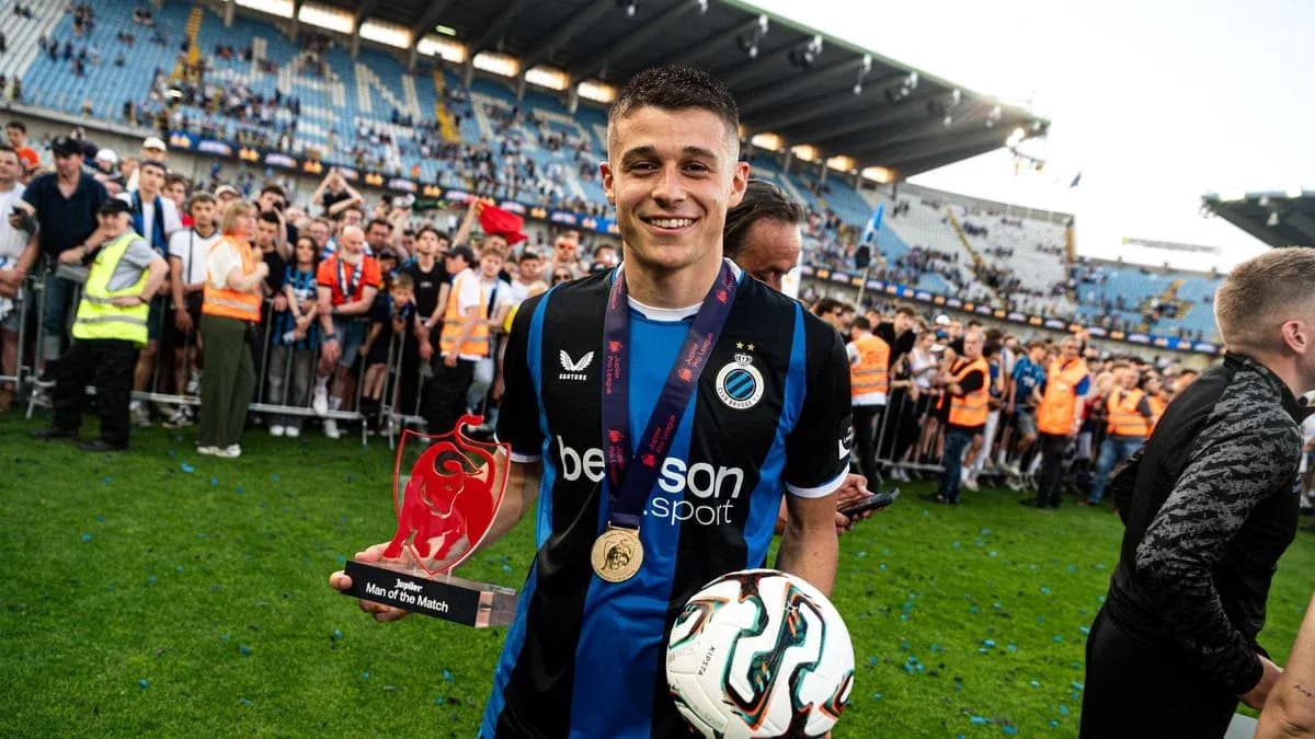 Player holding trophy and ball in celebration