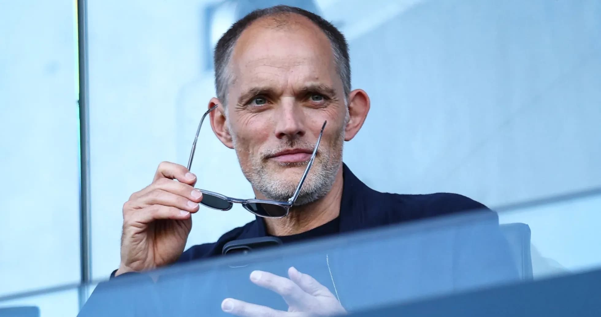 Man holding glasses, seated in viewing area