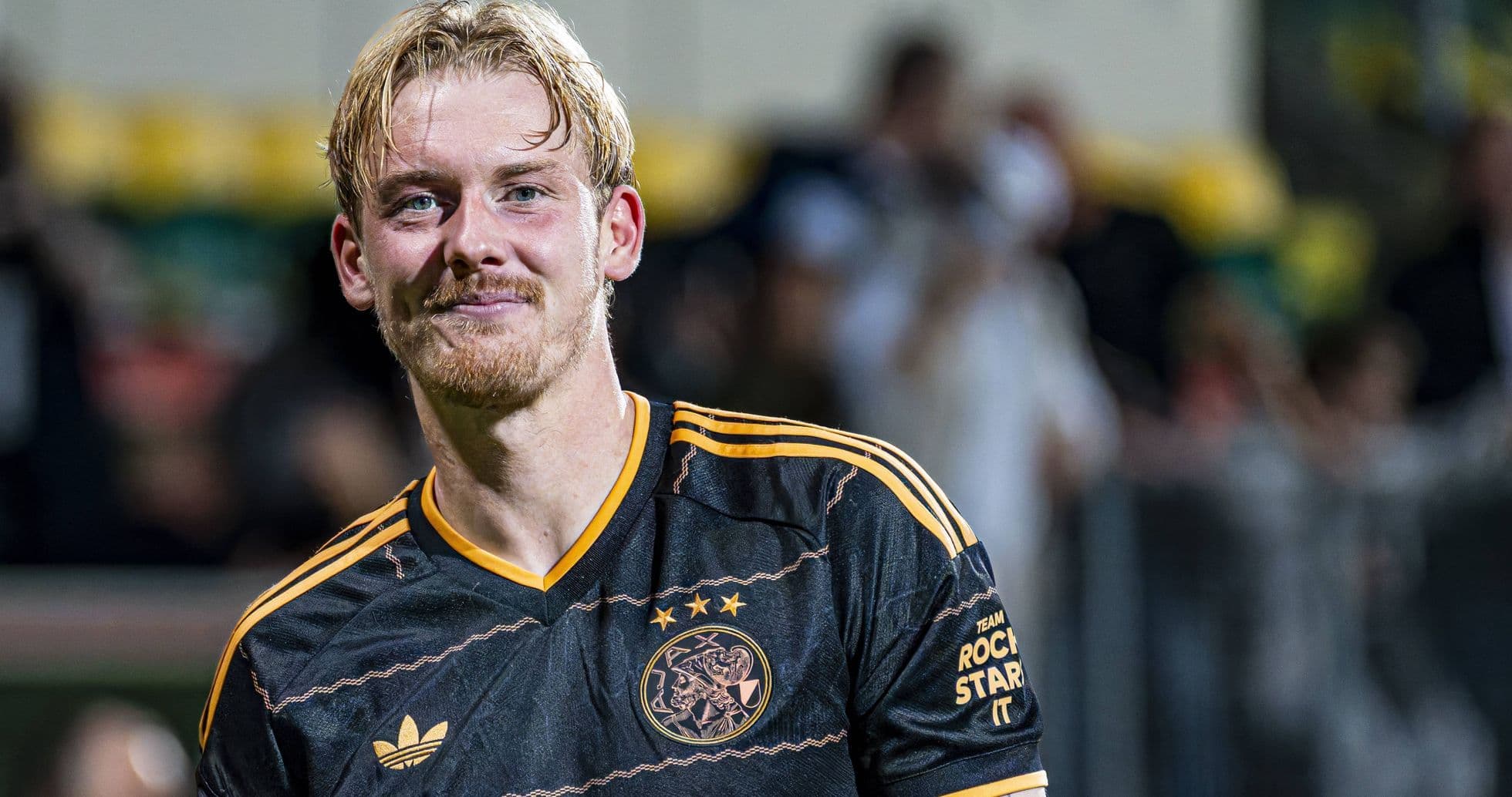Player smiling in Ajax jersey after match
